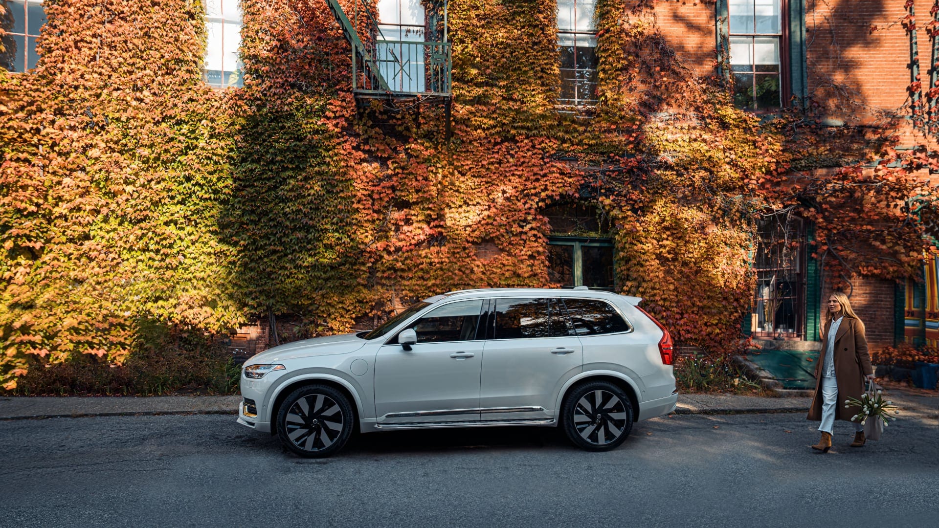Volvo XC90 Recharge parked in front of an ivy-covered brick building