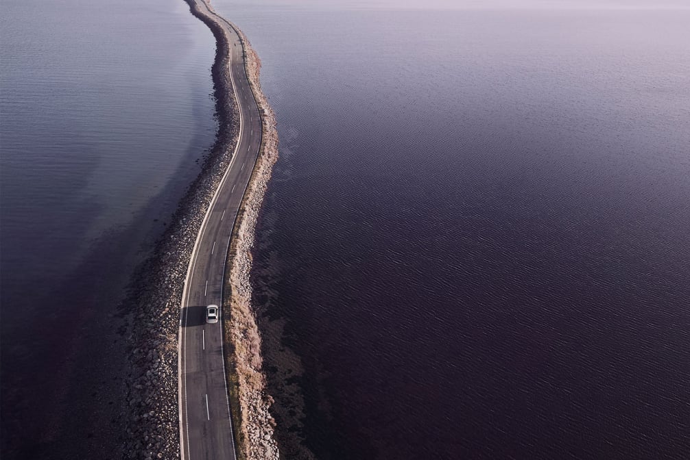 distant overhead view of a Volvo driving on a bridge
