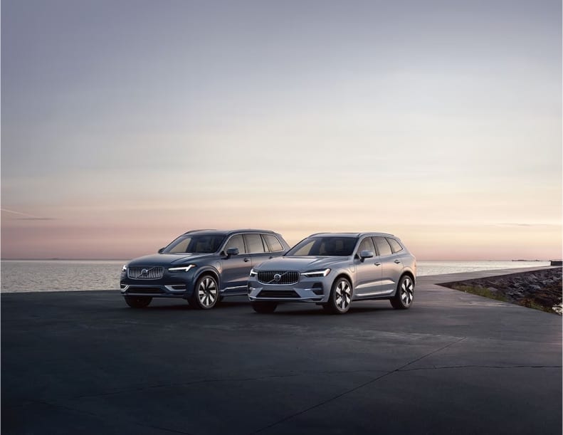 2 Volvo SUVs parked near the shore at sunset