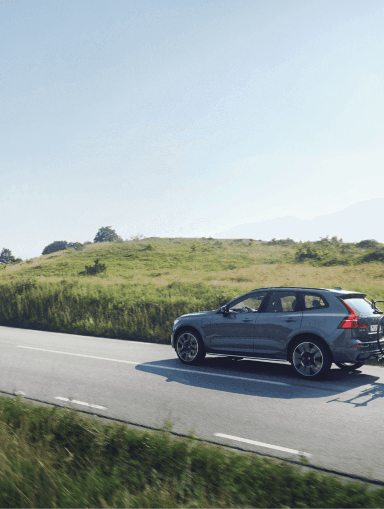 Blue Volvo driving down a country road
